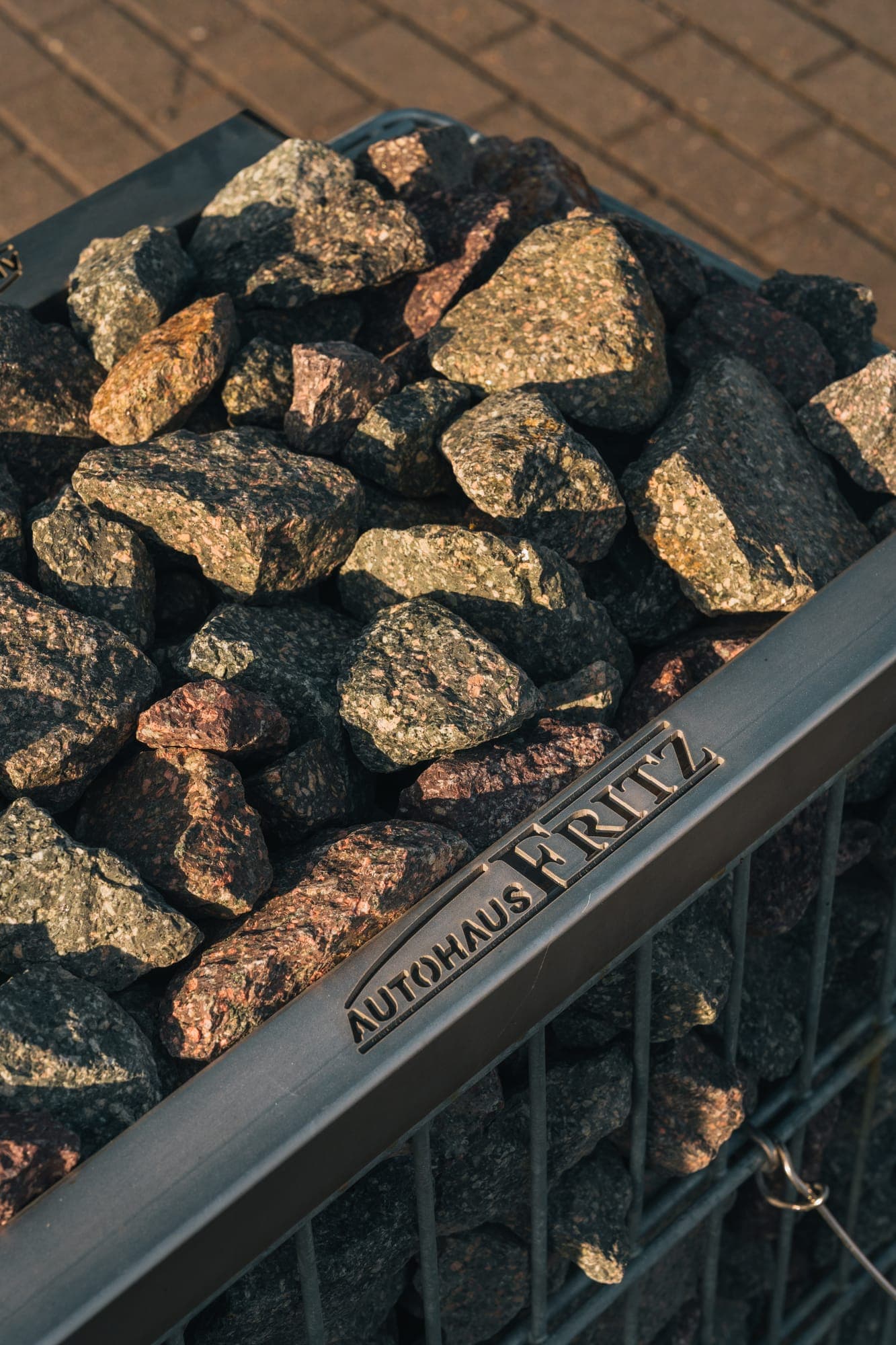 Metal ‘Autohaus Fritz’ lettering on the stone gabions at the entrance