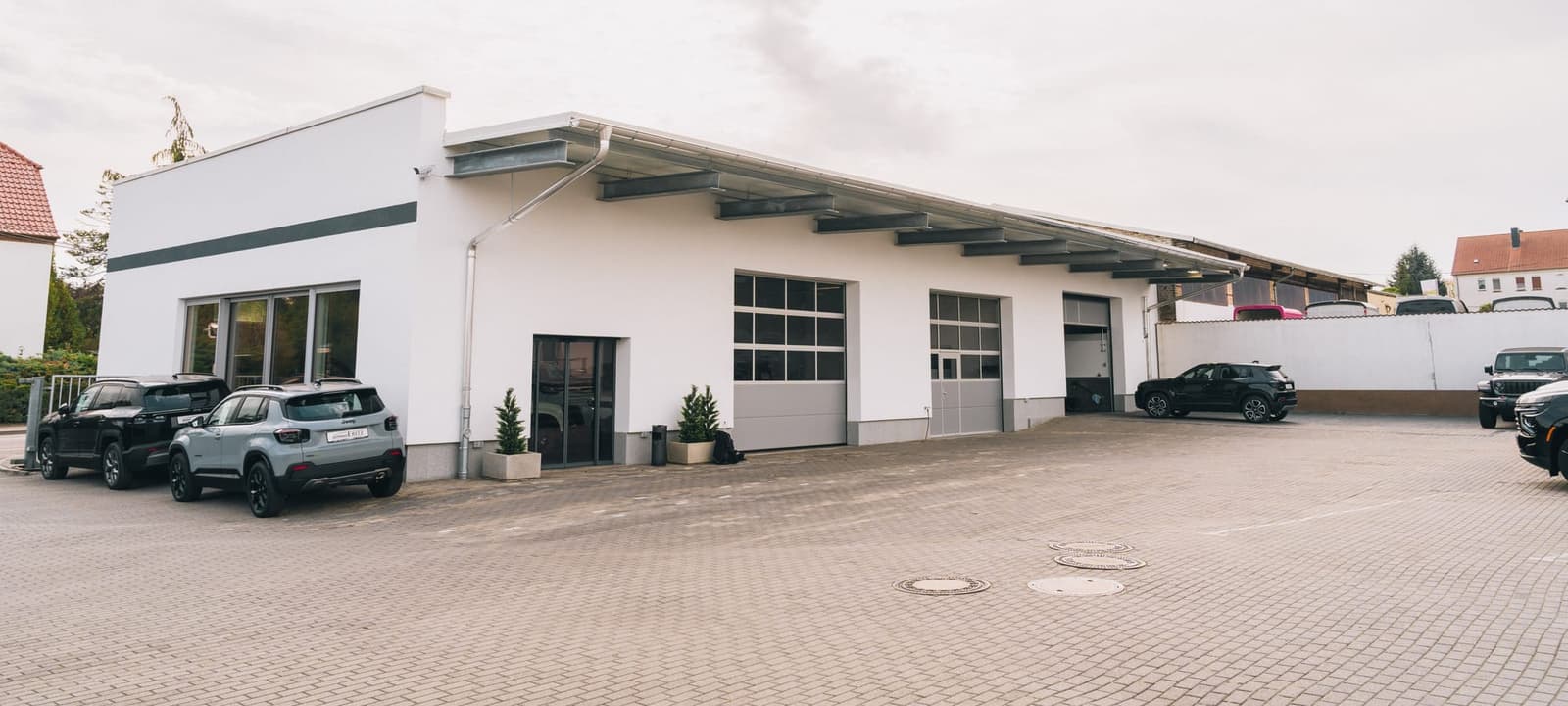 The second building on the site with hall doors, vehicles in front of it