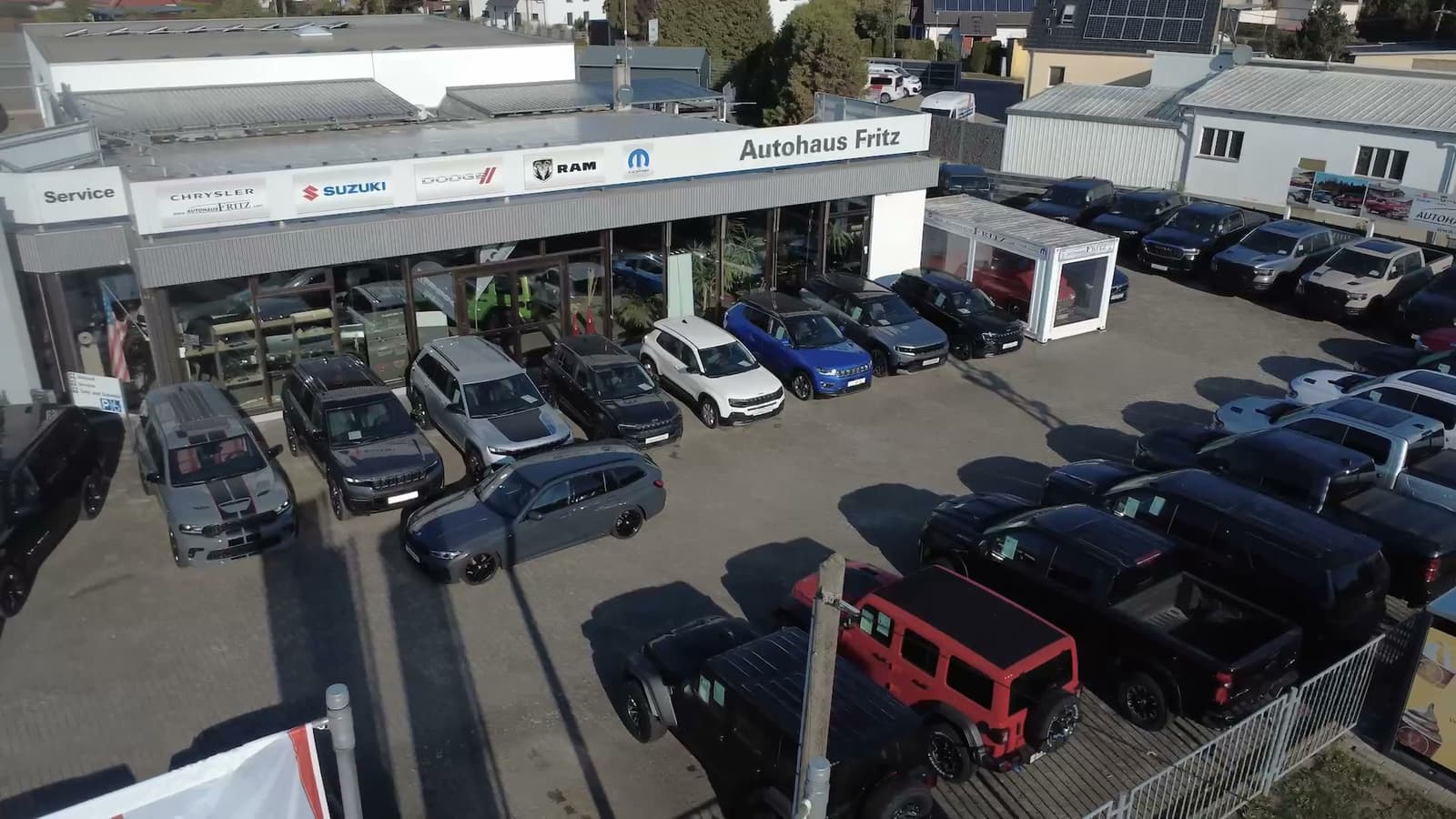 Autohaus Fritz in Oppin from above: the sales building with brand signs and the Autohaus Fritz lettering, a row of vehicles in front