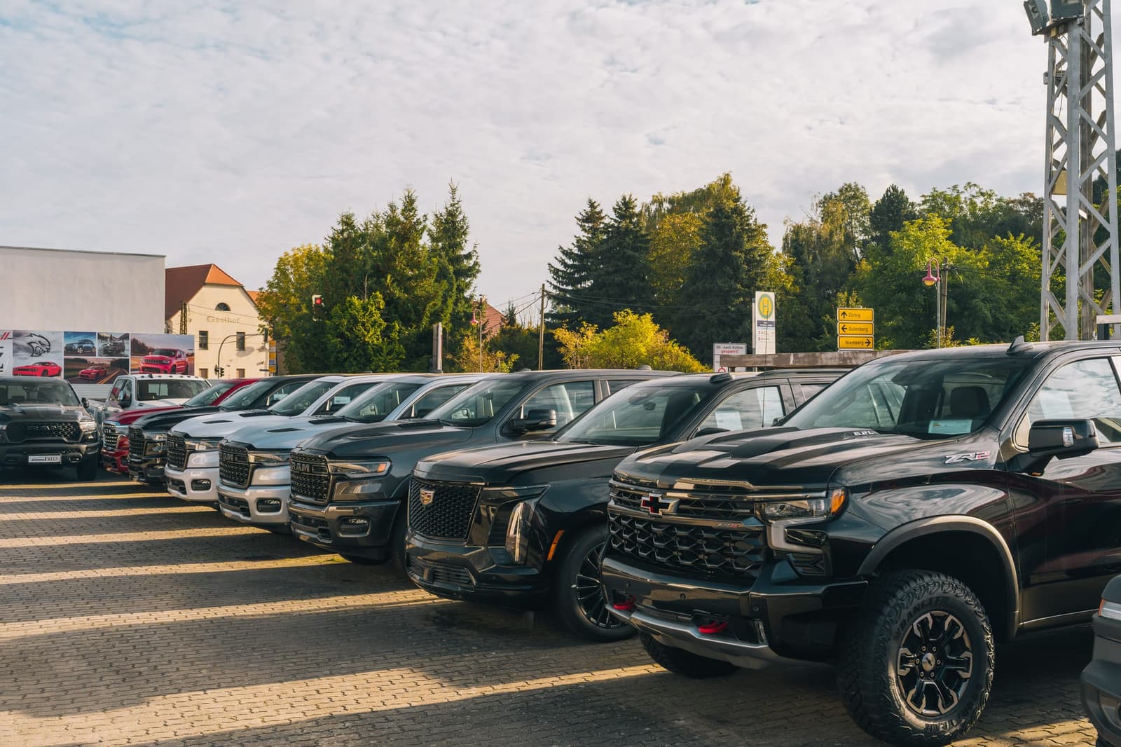 A row of large pickups and SUVs in the yard