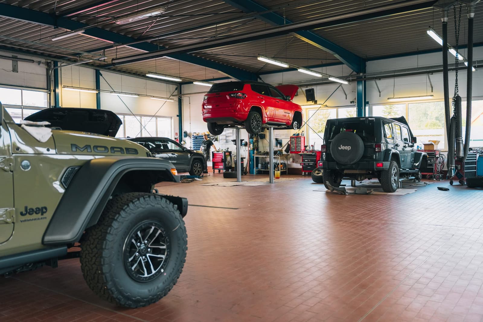 The Autohaus Fritz workshop: a Jeep in front, vehicles on lifts behind it