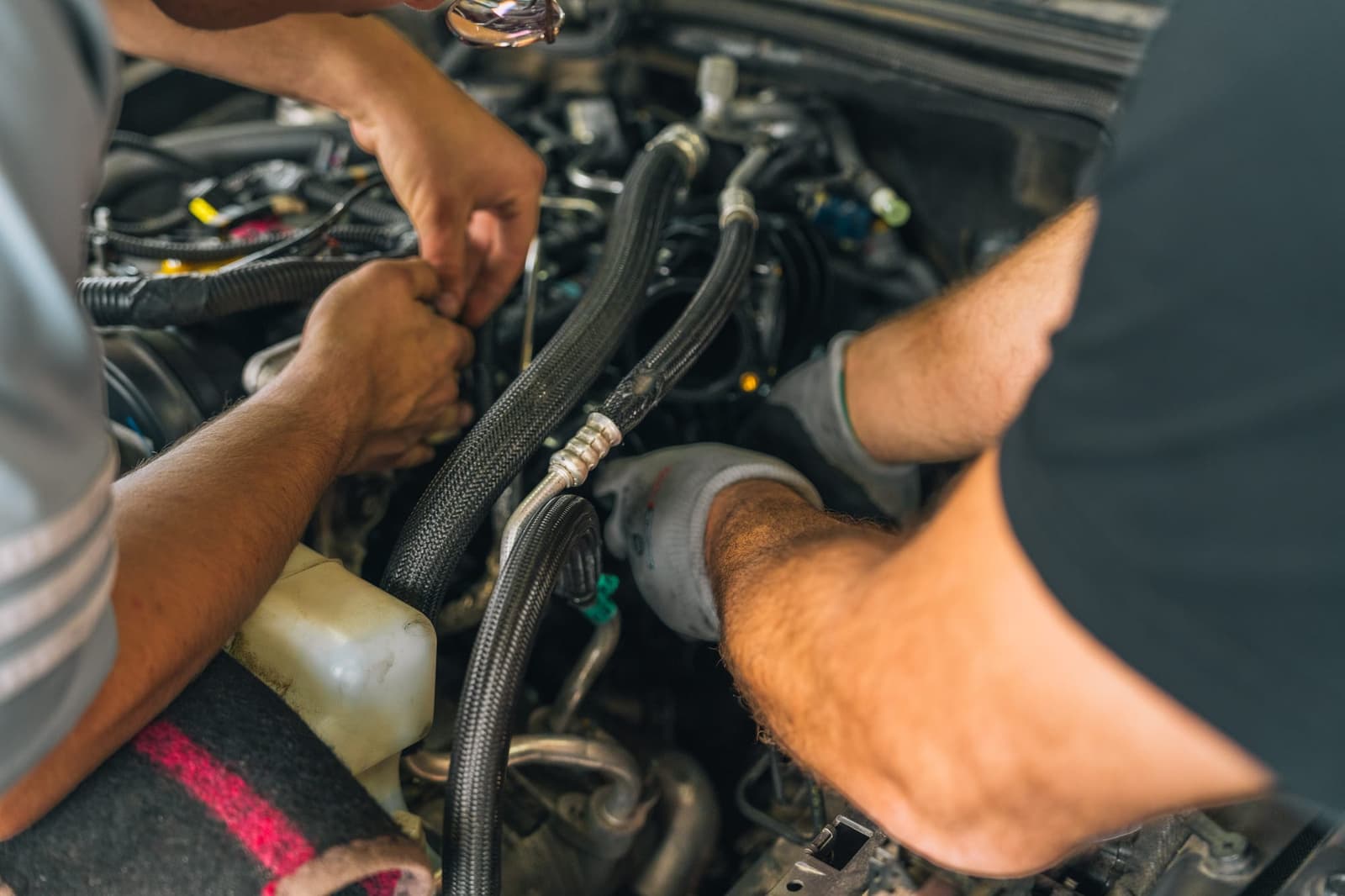 A mechanic’s hands at work in an engine bay